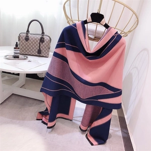 Detail of pink and blue color-block scarf draped elegantly on a gold chair in a cozy room