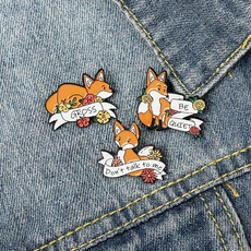 Detailed view of three fox enamel pins with floral accents on a blue denim jacket
