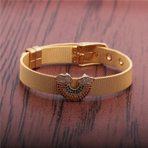 Golden mesh strap bracelet featuring a colorful rainbow zircon buckle on wood surface