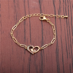 Golden hip hop chain bracelet with zircon heart and footprint charm on wood background