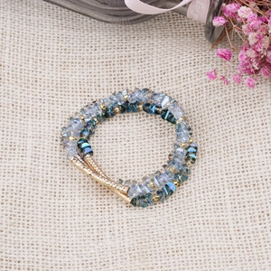 Detailed shot of multi-layer beaded bracelet with blue crystals and golden metal tubes