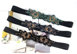 Detailed view of floral elastic waist belts with colorful crystal rhinestones and beads