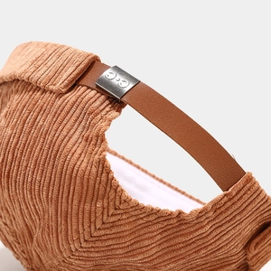 Detail of camel corduroy hat with adjustable leather strap and silver metal buckle closure