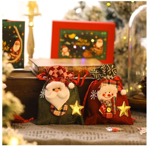 Detail of linen Christmas gift bags with 3D Santa and snowman dolls plus gold stars