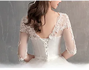 Dettaglio dell'abito da sposa bianco con corsetto stringato sulla schiena e pizzo fine