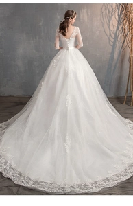 Dettaglio posteriore dell'abito da sposa in pizzo con schiena a V e lungo strascico ricamato