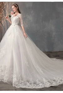 Dettagli dei ricami floreali in pizzo sullo strascico dell'abito da sposa con scollo a V