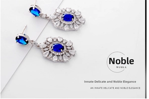 Detail of luxury vintage jewelry set with blue oval stones and white zircon on white paper