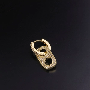 Close-up of gold earring with cubic zirconia and rectangular cutout pendant detail