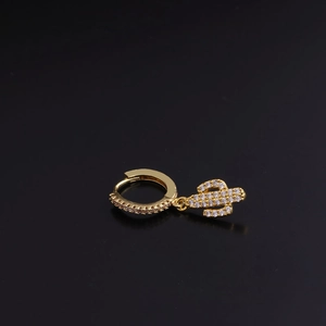 Close-up of a golden cactus pendant earring with sparkling zircon inlay on black background
