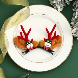 Detail von Weihnachts-Rentier-Haarspangen mit Schneemann und gelbem Pompon auf Teller