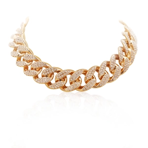 Exaggerated gold chain necklace with full crystal rhinestones in a minimalist studio setting