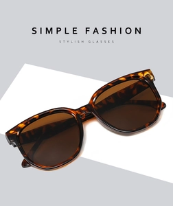 Détail de lunettes de soleil rétro écaillées sur un présentoir géométrique moderne
