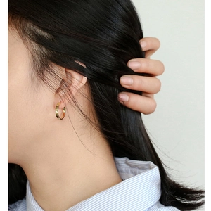 Elegant 925 silver needle gold hoop earrings worn by a model in a striped shirt