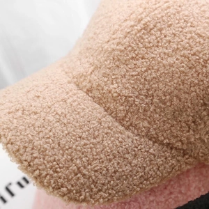 Macro detail of plush sherpa texture on beige and pink winter baseball cap