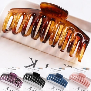Detail view of large geometric hair claws in amber, purple, black, blue, and pink