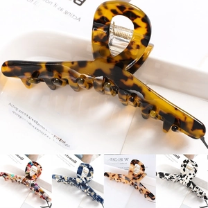Detail of large acetate hair claw clips in tortoiseshell and marble patterns with metal spring