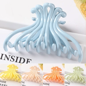 Close-up of wavy geometric hair claws in light blue, yellow, beige, orange and green