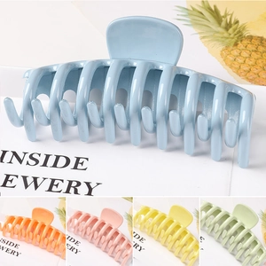Detailed view of large hollow geometric hair claws in various vibrant macaron colors