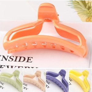 Detail view of large hollow star hair claws in orange, green, beige, purple and yellow