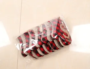 Close-up of red and black buffalo plaid Christmas stocking banner clips in OPP bag