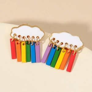 Primer plano de pendientes de nube arcoíris con colgantes de colores sobre fondo beige