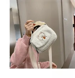 Close-up of white plush lamb wool crossbody bag with cute teddy bear embroidery detail