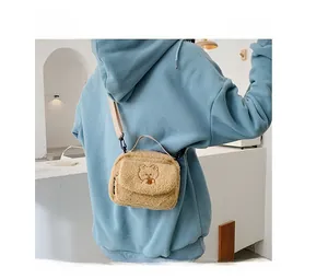 Detail showing cute brown bear embroidery on soft lambswool crossbody bag with strap