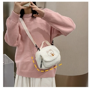 Close-up of white fleece crossbody bag featuring a cute bear embroidery and strap