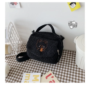Close-up of black lamb wool bag with cute cartoon bear embroidery in a cozy ins-style setup