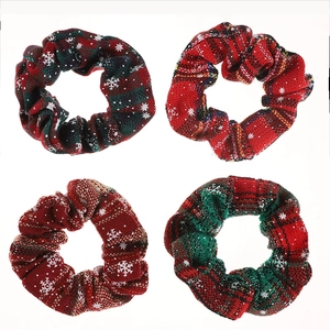 Christmas themed fabric hair scrunchies with red and green plaid patterns and white snowflakes