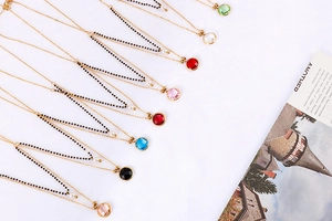 Detailed close-up of colorful gemstone pendants on gold-tone double-layered necklaces