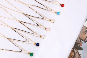 Close-up of double-layer gold necklaces with colorful round crystal stone pendants