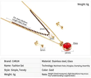 Detail view of double-layer gold necklace set with red glass charm and white pearl
