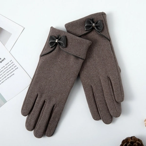 Detail of warm brown winter gloves with a stylish leather bow and soft felt texture