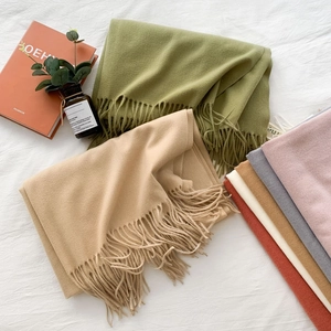 Close-up of assorted cashmere-feel scarves with fringe details in various vibrant colors