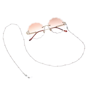 Detailed close-up of frameless petal-edge sunglasses with long white pearl lanyard