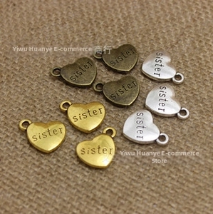 Detail van hartvormige sister-bedeltjes in goud, zilver en brons voor DIY-sieraden
