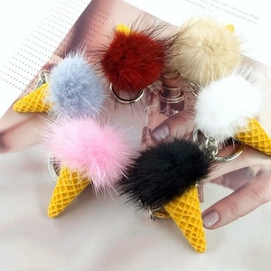 Close-up of six colorful plush ice cream cone keychains with metal rings on a magazine