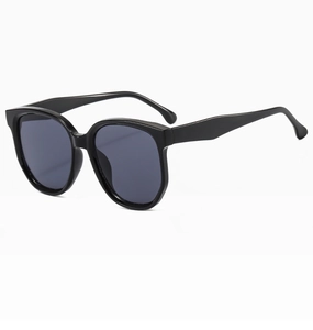Détail de lunettes de soleil noires oversize avec montures brillantes et verres gris