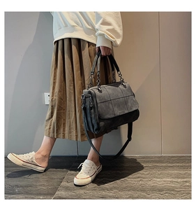 Borsa Boston grigia trapuntata con tracolla a catena mostrata da una modella indoor