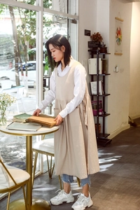 Detail of beige cotton linen apron with side pockets in a professional cafe setting