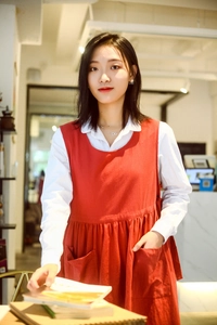 Detail of red cotton apron with two front pockets and pleated waist for comfort