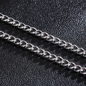 Polished stainless steel Cuban link chain necklace on premium black leather texture