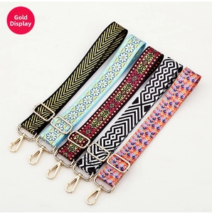 Close-up of five patterned bag straps with adjustable gold-tone lobster clasps hardware