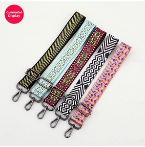 Detail view of five adjustable patterned replacement purse straps with gunmetal hardware hooks
