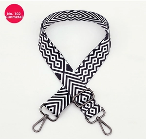 Close-up of geometric black and white woven strap with adjustable gunmetal hardware