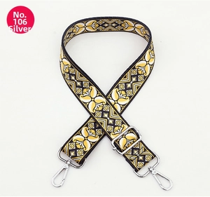Detail of yellow floral woven bag strap with silver metal hooks and adjuster
