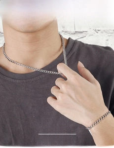 Men's silver stainless steel curb chain necklace and bracelet set on a male model