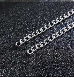 Macro shot of polished stainless steel curb chain links with a smooth metallic finish